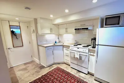 a kitchen with white appliances and a white refrigerator at Cozy Boho Studio Suite in Calgary