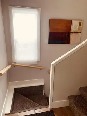 a room with stairs with a window and a painting at Charming Inner City Home in Calgary