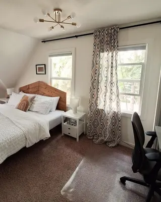 a bedroom with a bed and a window and a chair at Charming Inner City Home in Calgary