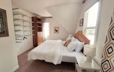 a white bedroom with a bed and a window at Charming Inner City Home in Calgary