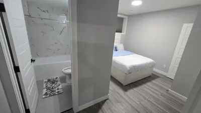 a small bathroom with a bed and a toilet at Royaldee Cozy Home in Calgary