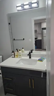a bathroom counter with a sink and a mirror at Royaldee Cozy Home in Calgary