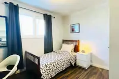 a bedroom with a bed and a window at Private Rooms in a Wonderful House in Hay River
