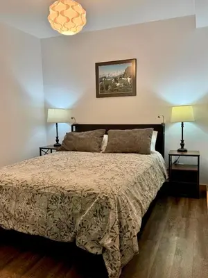 a bedroom with a large bed with two lamps at Suite on the Bay in Marsh Lake