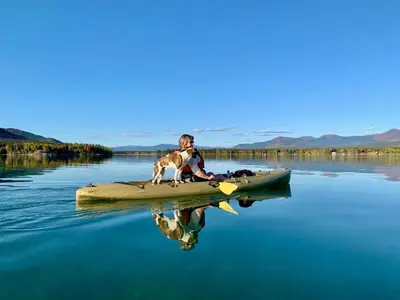 a man and a dog on a kayak in the water at Suite on the Bay in Marsh Lake