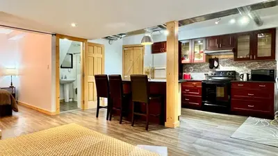 a kitchen with a bar with chairs and a stove at Suite on the Bay in Marsh Lake