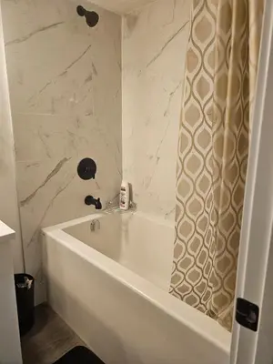 a white bath tub in a bathroom with a shower at Affordable Comfort in Creekstone SW in Calgary
