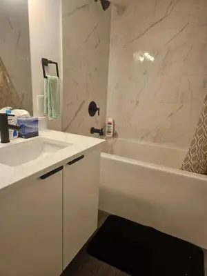 a bathroom with a white tub and a sink and a bath tub at Affordable Comfort in Creekstone SW in Calgary