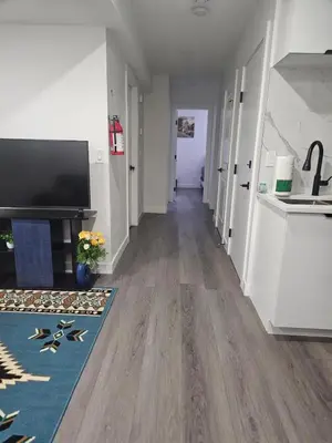 a hallway of a home with wooden floors at Affordable Comfort in Creekstone SW in Calgary