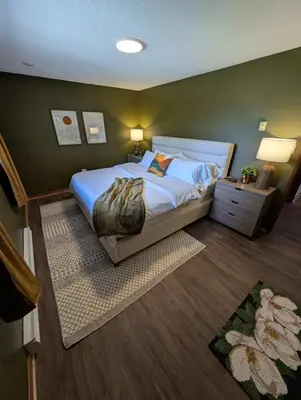 a bedroom with a bed and a green wall at Newly Renovated Shuswap Lake Cabin Multi-Family Retreat Sleeps 12 in Blind Bay