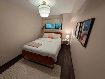 a bedroom with a bed and a chandelier at Newly Renovated Shuswap Lake Cabin Multi-Family Retreat Sleeps 12 in Blind Bay