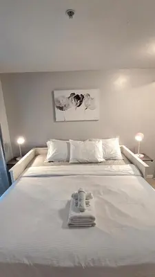 a white bed with towels on top of it at Bright 2BR Close to Seabus, and Lower Lonsdale in North Vancouver