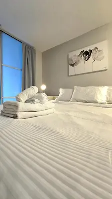a bedroom with two large white beds with a window at Bright 2BR Close to Seabus, and Lower Lonsdale in North Vancouver