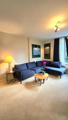 a living room with a blue couch and a table at Bright 2BR Close to Seabus, and Lower Lonsdale in North Vancouver