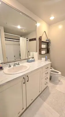 a bathroom with a sink and a mirror and a toilet at Bright 2BR Close to Seabus, and Lower Lonsdale in North Vancouver