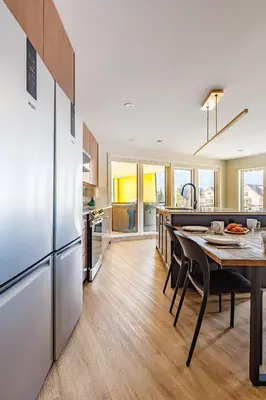 a kitchen with a table and a refrigerator at Ravens Nest - Private Hot Tub in Canmore
