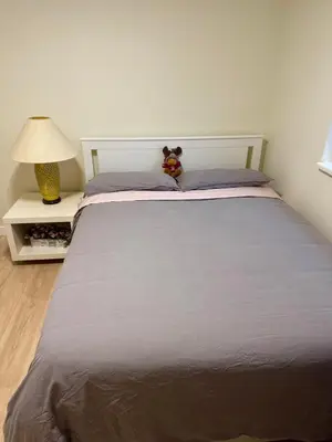 a bed with a teddy bear sitting on top of it at Maple & Moon in Richmond