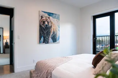 a bedroom with a picture of a bear on the wall at Revelstoke Mountain Penthouse in Revelstoke