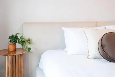 a bed with a wooden table next to a white bed at Revelstoke Mountain Penthouse in Revelstoke