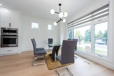 a dining room with a glass table and chairs at Luxury Home Near DT, New Build, High-End Features in Calgary