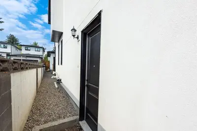 a doorway to a white building with a black door at Newly built 2 bedroom suite with kitchen & laundry in Calgary