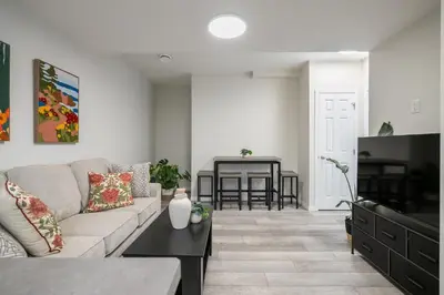 a living room with a couch and a table at 2BR Stylish & Private Suite SE! FREE Banff Pass, Netflix, Parking! in Calgary
