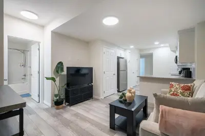a living room with a couch and a television at 2BR Stylish & Private Suite SE! FREE Banff Pass, Netflix, Parking! in Calgary