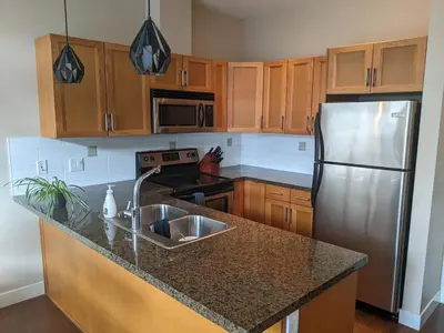 a kitchen with wooden cabinets and a stainless steel refrigerator at Copper Sky Paradise in West Kelowna