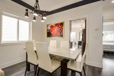 a dining room with a glass table and white chairs at Spacious Family Home in Vancouver in Vancouver