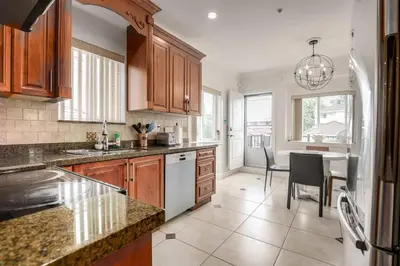 a kitchen with wooden cabinets and a dining room at Spacious Family Home in Vancouver in Vancouver