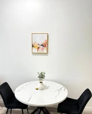 a white table with two chairs and a vase on it at Cozy 1-Bedroom with Downtown City views in Edmonton