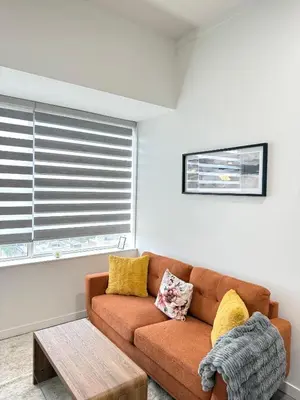 a living room with a brown couch and a table at Cozy 1-Bedroom with Downtown City views in Edmonton