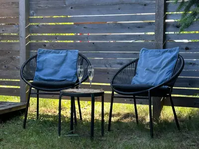 two chairs with blue cushions sitting next to a fence at Studio Cedar Guest Cottage in Duncan