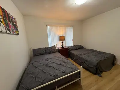 a bedroom with two beds and a window at Vancouver Home - Downtown 15 Min, Transit Access - Free Parking & Wi-Fi in Vancouver