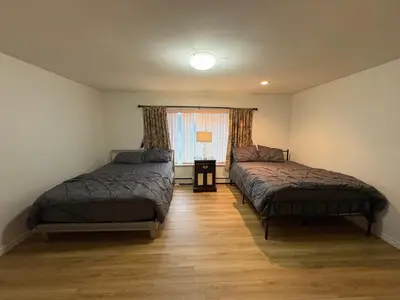 a bedroom with two beds and a window at Vancouver Home - Downtown 15 Min, Transit Access - Free Parking & Wi-Fi in Vancouver