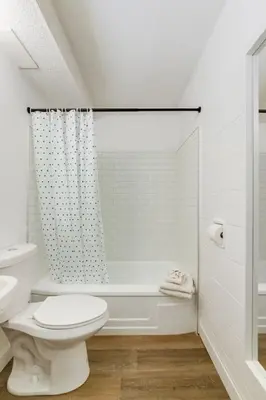 a white bathroom with a toilet and a shower at Gateway Suites Rocky Mountains stay near Banff in Canmore