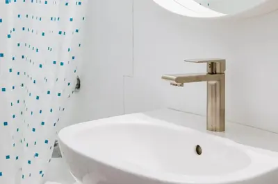 a bathroom with a sink and a shower curtain at Gateway Suites Perfect rest on your way to Banff in Canmore