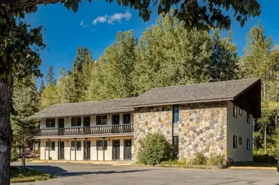 an old stone building with a gambrel roof at Gateway Suites Perfect rest on your way to Banff in Canmore