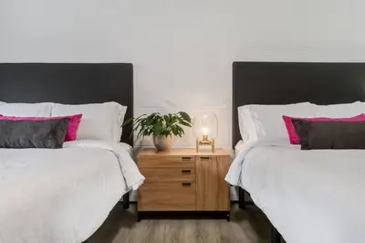 a bedroom with two beds and a night stand with a plant at Gateway Suites Charming Stay perfect for 4 Guests in Canmore
