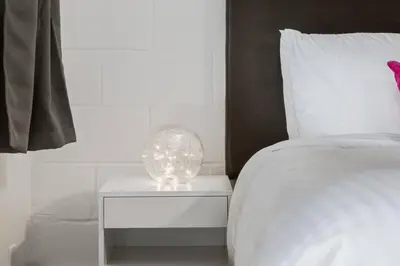 a white bed with a glass sphere on a night stand at Gateway Suites Charming Stay perfect for 4 Guests in Canmore