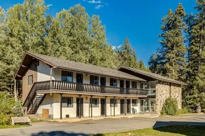 an exterior view of a building with trees at Gateway Suites near Banff in Canmore