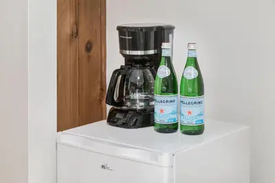two bottles of wine sitting on a counter with a coffee maker at Gateway Suites Perfect Escape to explore Banff in Canmore