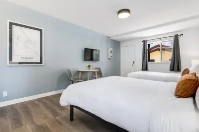 a bedroom with two beds and a table at Gateway Suites Lovely views near Banff in Canmore