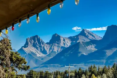 a view of mountains through a window with christmas lights at Gateway Suites Cozy stay to explore Banff and Canmore in Canmore
