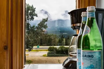 a bottle of wine sitting on a counter next to a window at Gateway Suites Cozy stay to explore Banff and Canmore in Canmore