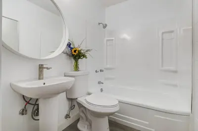 a bathroom with a toilet and a sink and a mirror at Gateway Suites Sweet Getaway near Canmore and Banff in Canmore