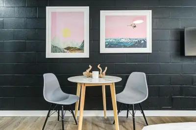 a table and chairs in a room with a wall at Gateway Suites Cozy Getaway Near Banff and Canmore in Canmore