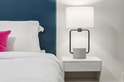 a bedroom with a bed and a lamp on a nightstand at Gateway Suites Cozy Getaway Near Banff and Canmore in Canmore