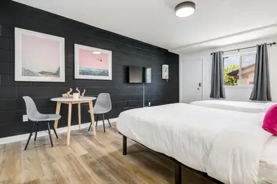 a bedroom with a bed and a table and chairs at Gateway Suites Cozy Getaway Near Banff and Canmore in Canmore