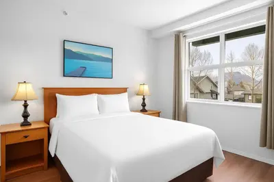 a bedroom with a large white bed and a window at Stylish 1BR Haven in CanmoreDT near Banff Sleeps 4 in Canmore